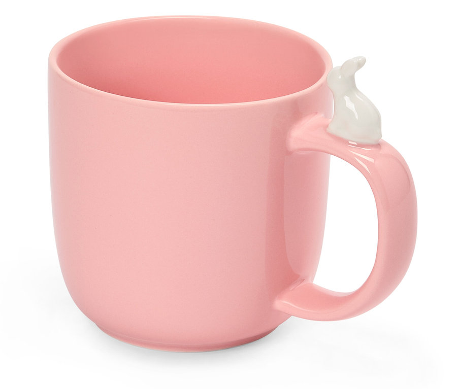Tasse rose avec un lapin blanc sur la poignée.