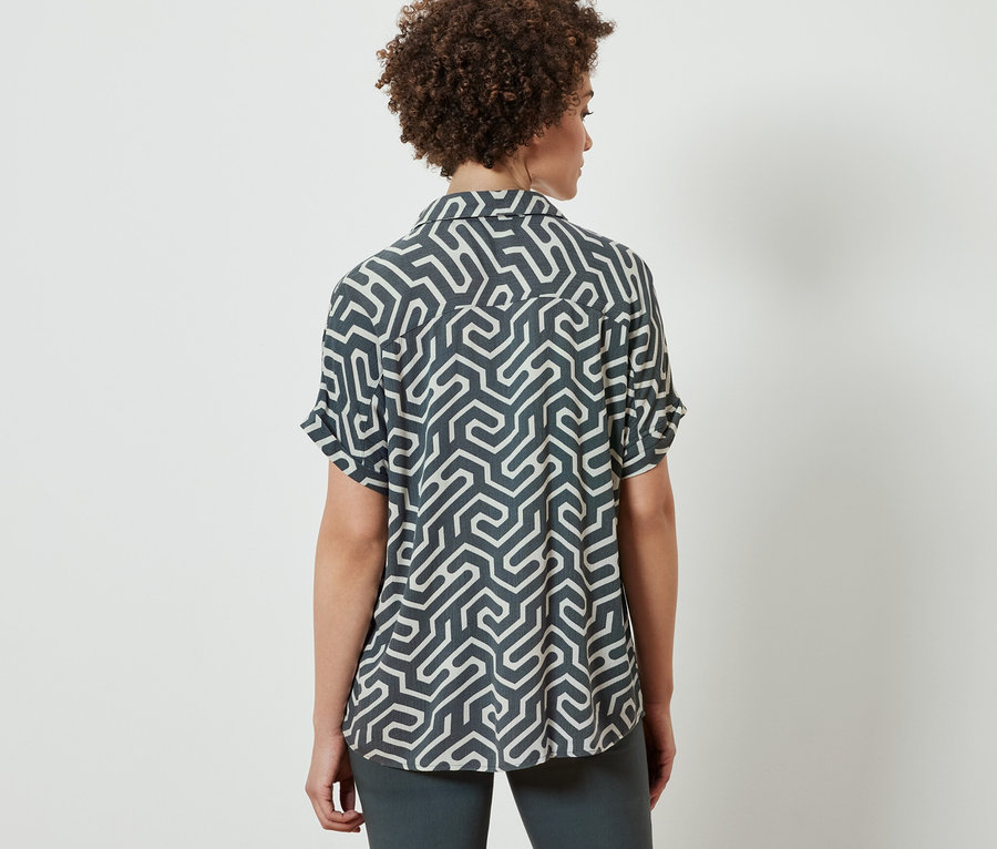 Femme vue de dos portant une blouse imprimée.