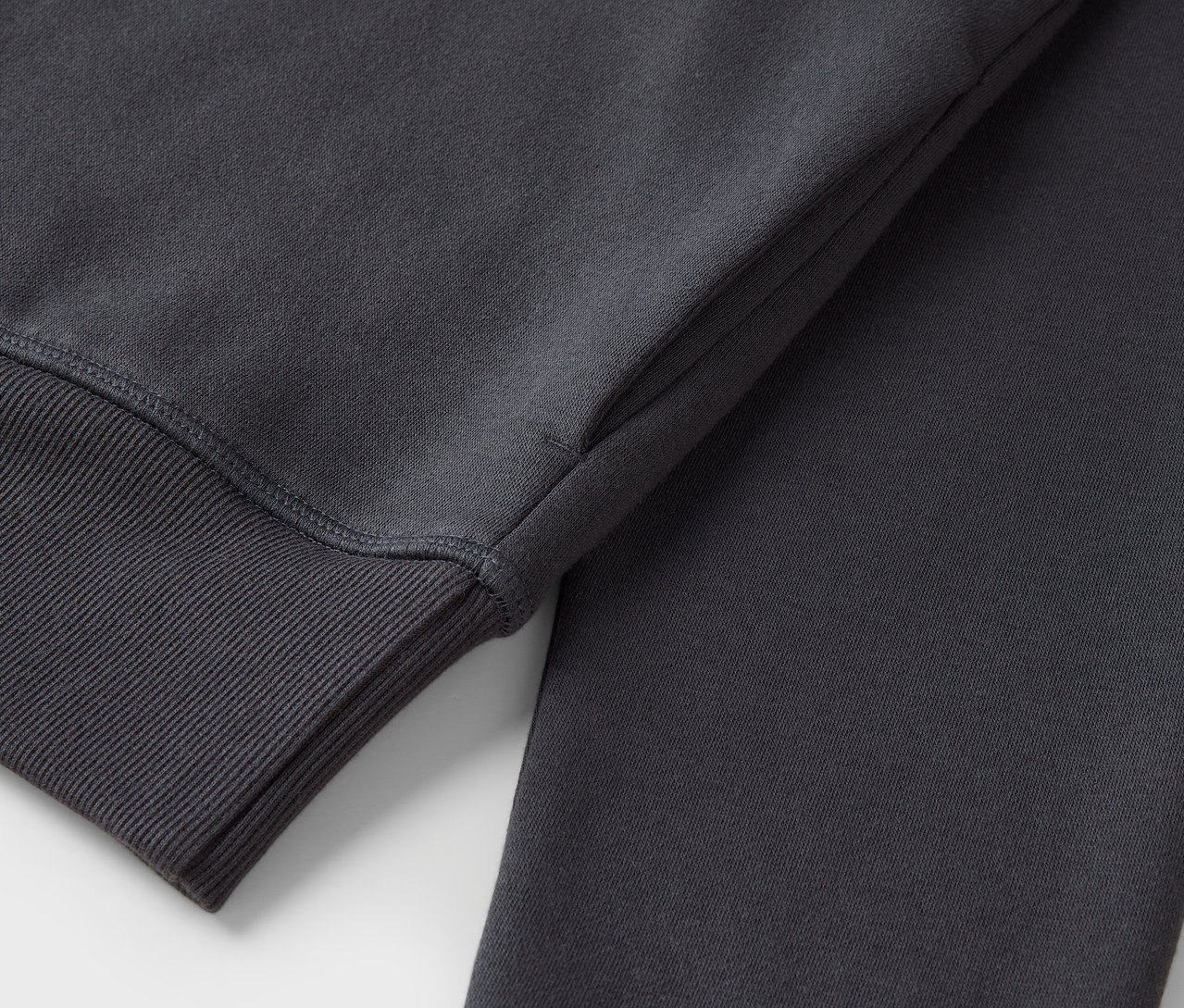 Gros plan sur un sweat-shirt gris avec une bordure côtelée sur la manche.