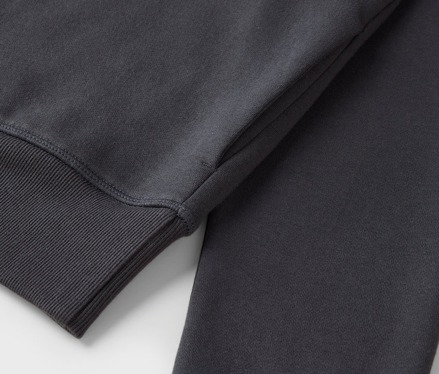 Gros plan sur un sweat-shirt gris avec une bordure côtelée sur la manche.