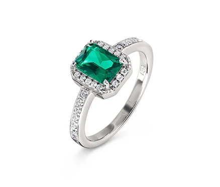 Bague en argent avec une pierre émeraude rectangulaire et de petites pierres claires.