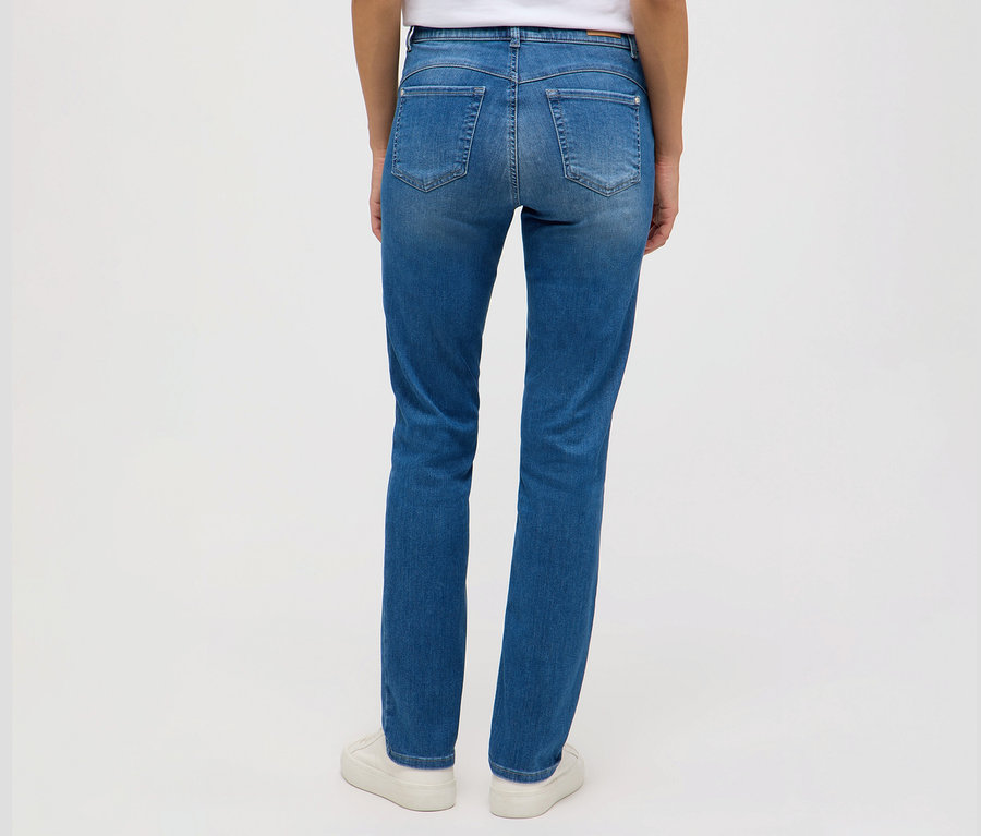 Vue arrière d'une femme portant un jean Angels « Cici Push-Up », coupe slim et des baskets blanches.