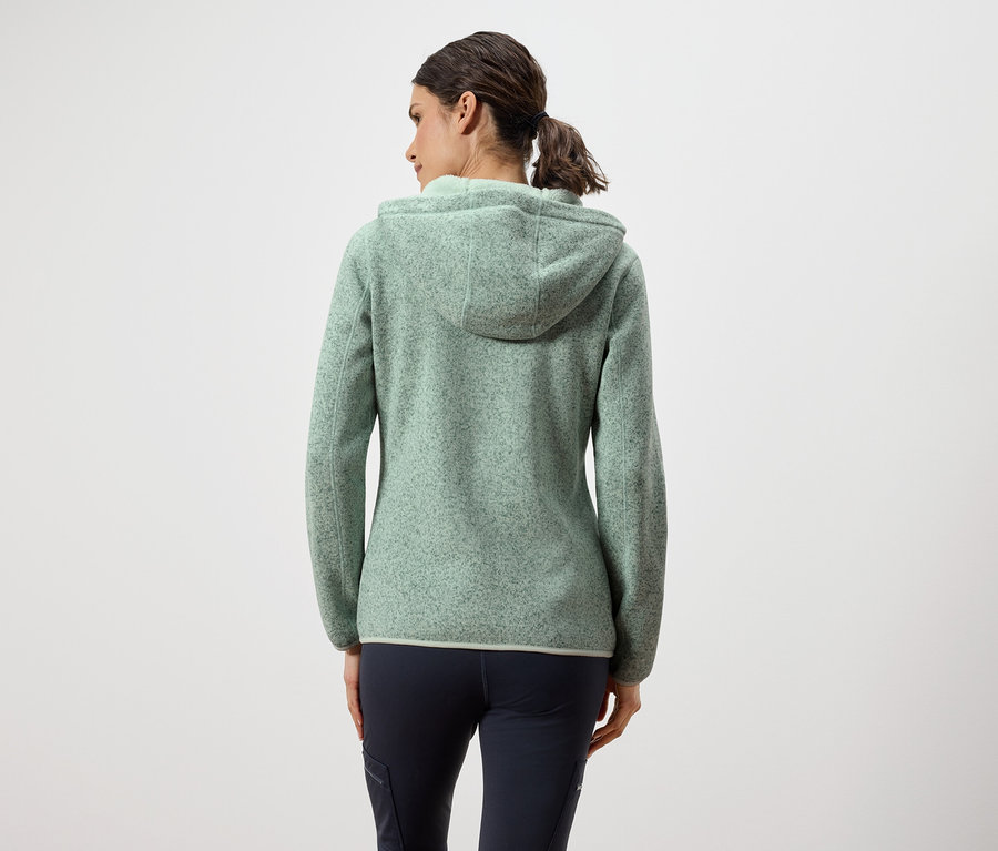 Vue arrière d'une femme portant un pull en laine polaire vert à capuche et un pantalon bleu marine.