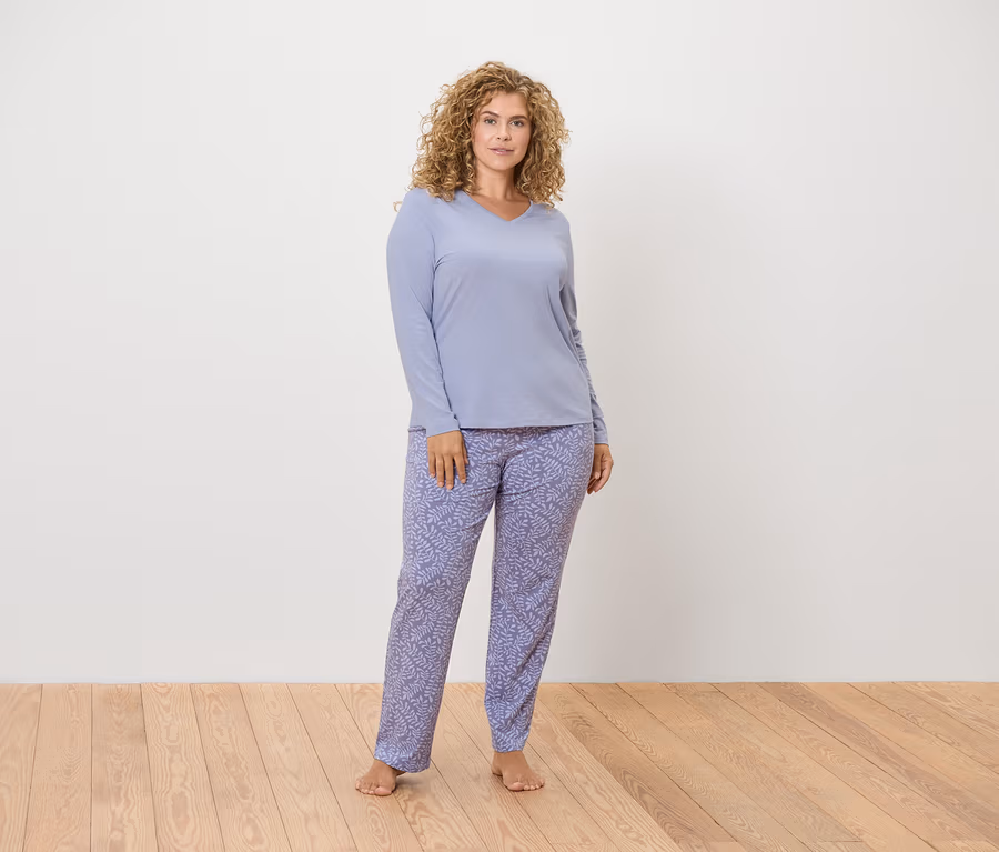 Femme posant en pyjama lilas clair à manches longues avec un motif floral.