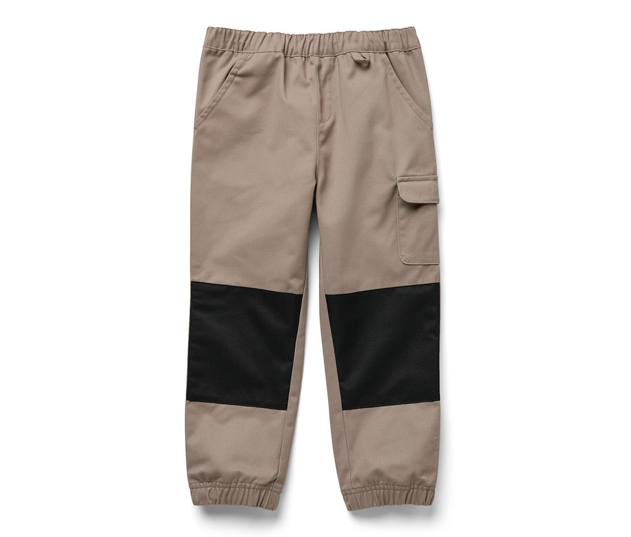 Un pantalon d'extérieur beige pour enfant avec des patchs noirs sur les genoux.