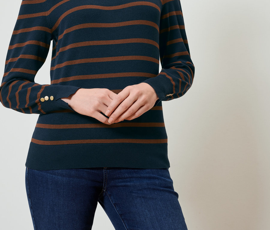 Femme portant un pull rayé et un jean.