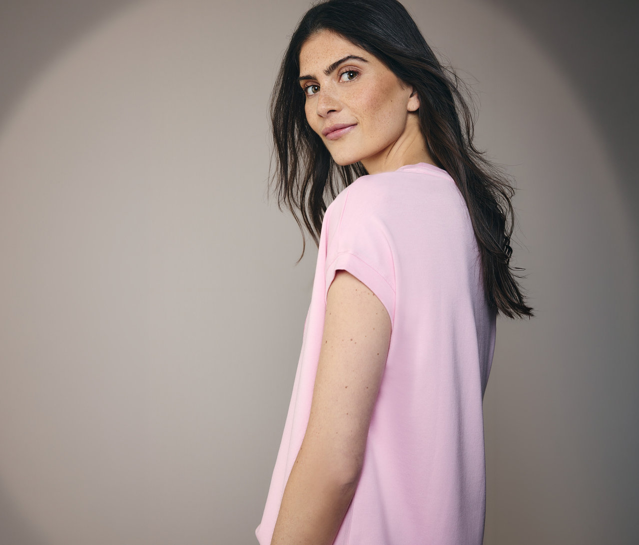 Femme regardant par-dessus son épaule portant un t-shirt à motif CECIL.