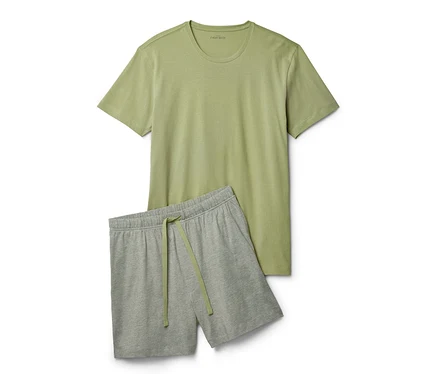 Un t-shirt vert clair et un short gris sont côte à côte.