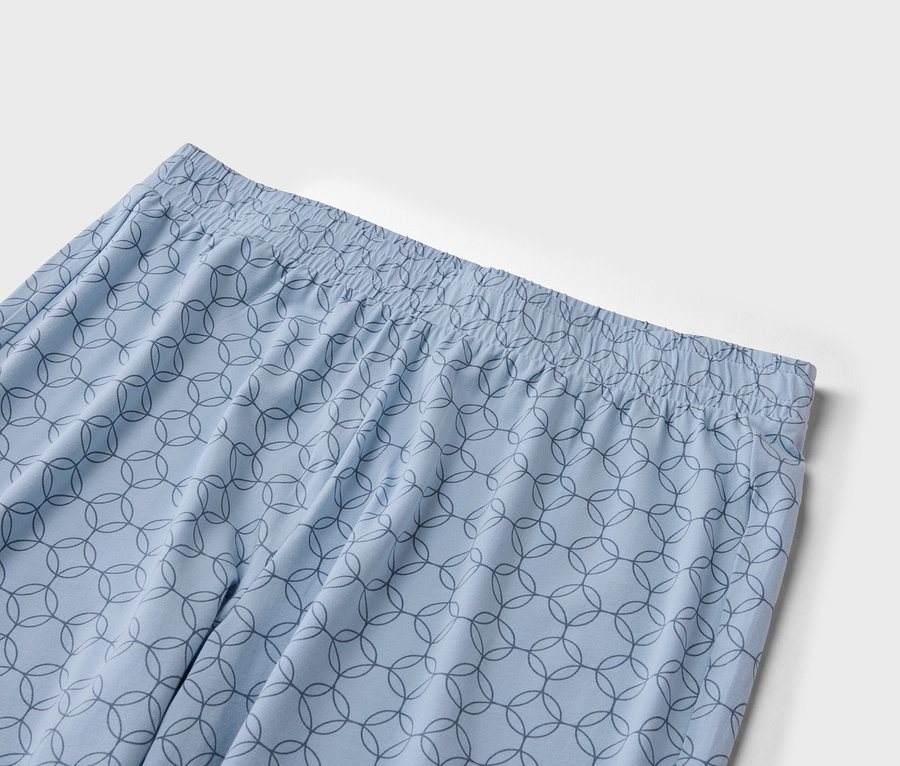 Gros plan d'un pantalon bleu clair avec une taille élastique et un motif de cercles qui se croisent.