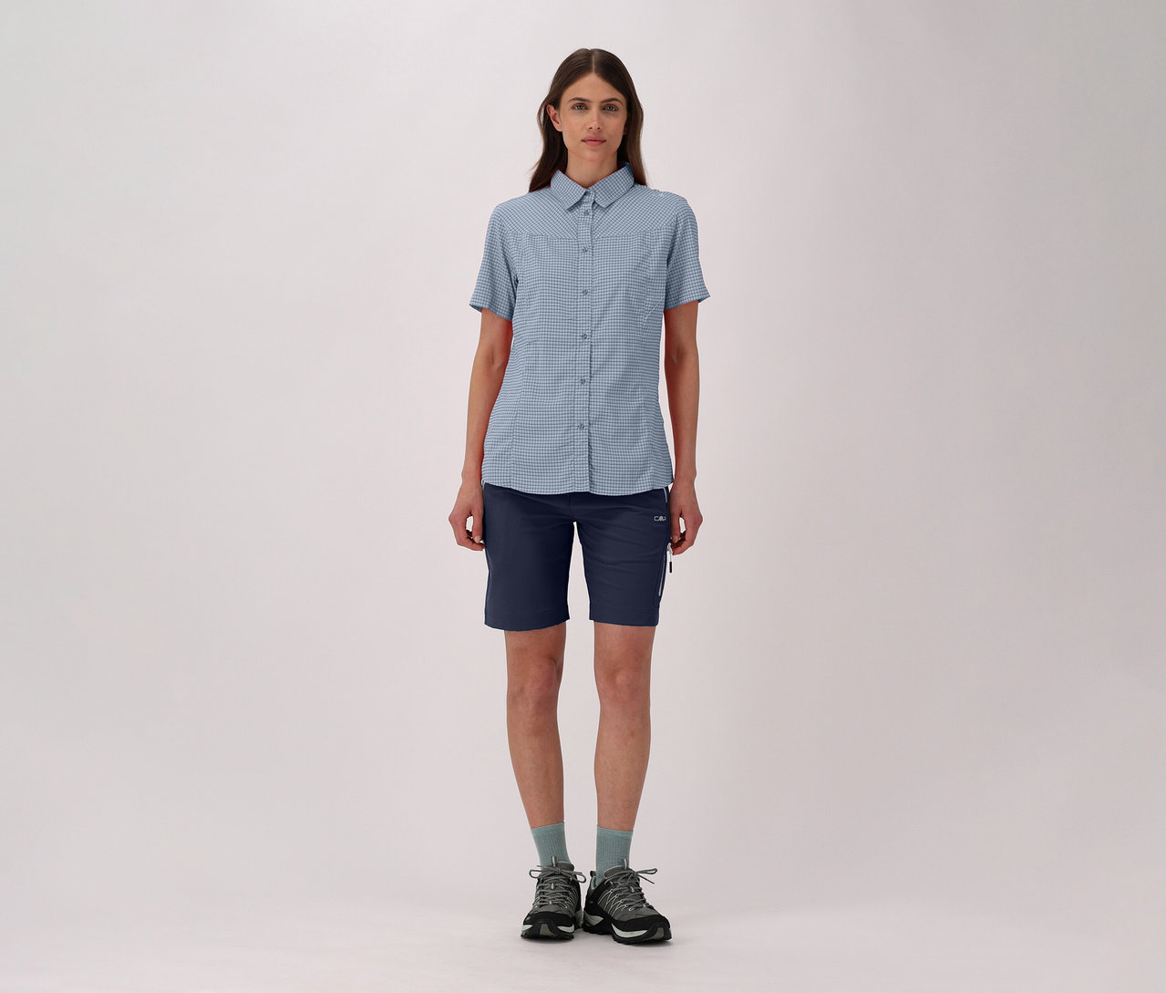 Femme en chemise à carreaux et bermuda stretch 4 directions CMP pour femme, avec chaussettes et chaussures de randonnée.