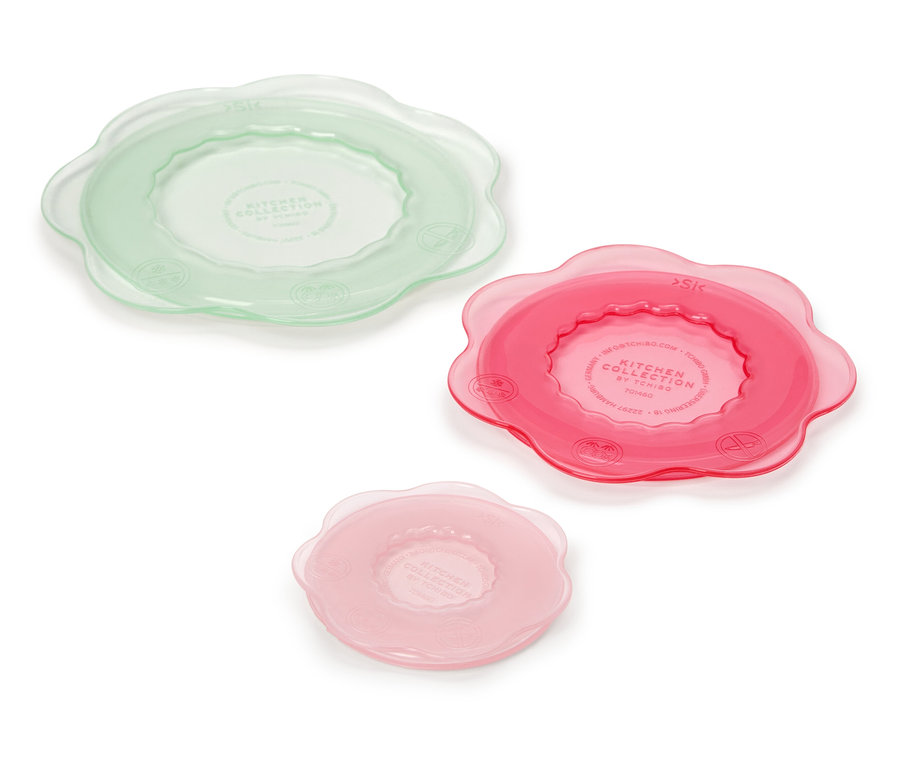 Trois couvercles de cuisine en vert, rose et rose clair reposent sur un fond blanc.