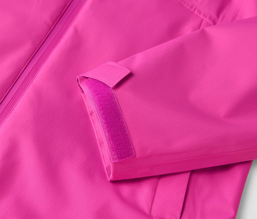 Gros plan d'une veste rose avec fermeture éclair et velcro sur la manche.