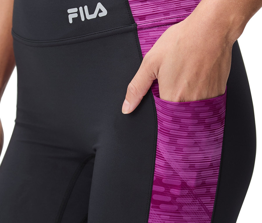 Femme portant un legging noir avec motif rose et logo Fila.