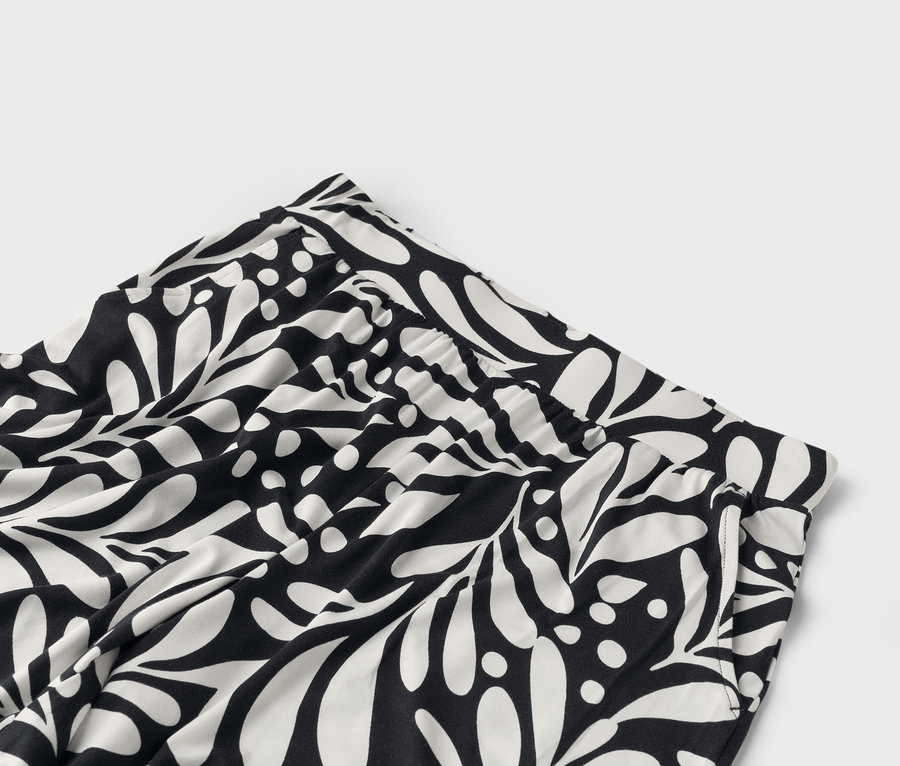 Gros plan d'un pantalon noir et blanc à motifs de feuilles.