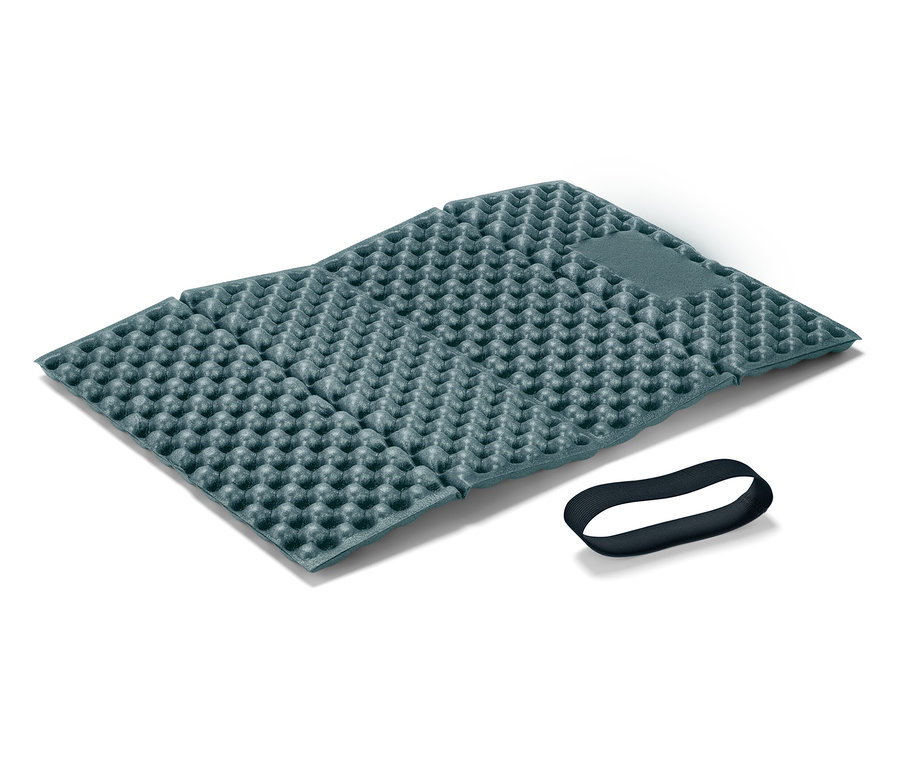 Un tapis de sol pliable bleu foncé avec une texture à picots et un élastique noir reposent sur un fond blanc.