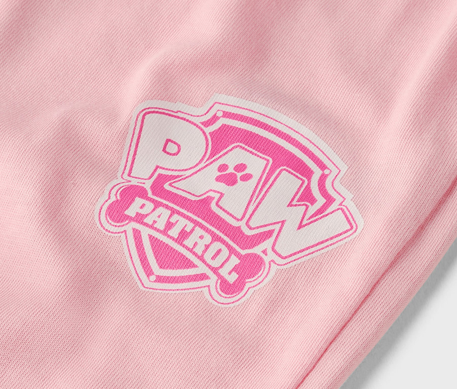 Gros plan d'un vêtement rose avec un logo Paw Patrol blanc et rose.