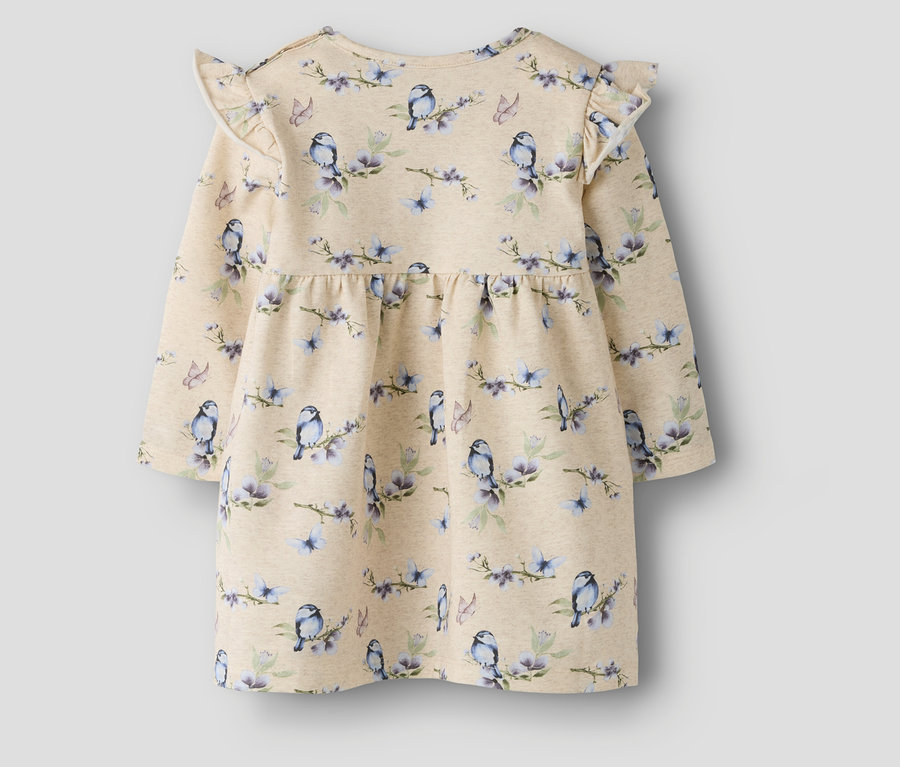 Gros plan sur une robe pour bébé NAME IT à motifs d'oiseaux et de fleurs avec des manches à volants.