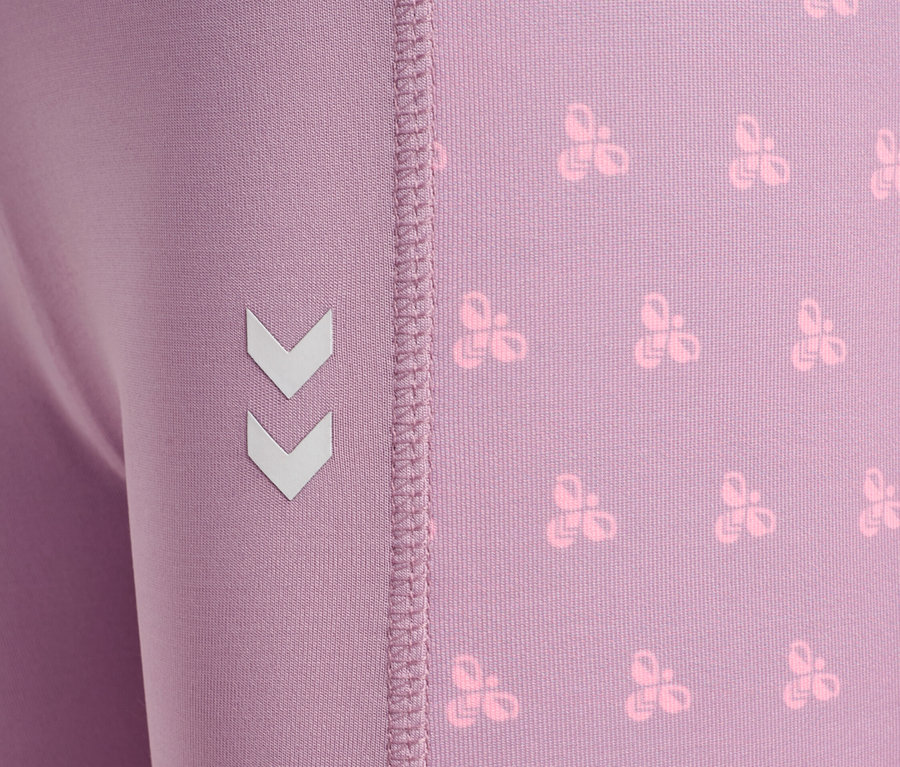 Gros plan d'un legging violet avec un motif répétitif et le logo d'angle sur le côté.
