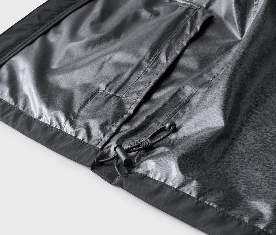 Gros plan sur l'intérieur d'une veste grise avec poche et cordon de serrage.