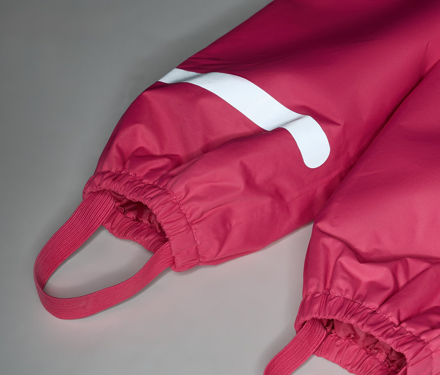 Gros plan sur un pantalon rose avec une bande blanche et des élastiques.