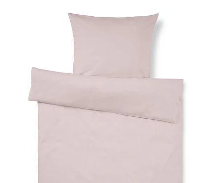 Parure de lit rose clair comprenant un oreiller et une housse de couette, la housse étant repliée en haut.