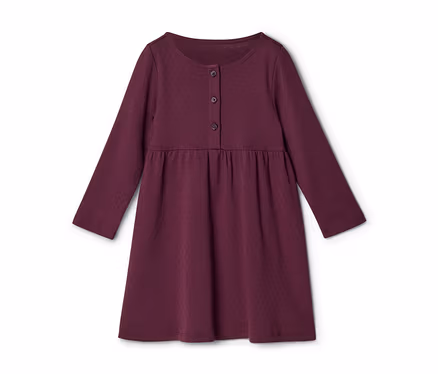 Une robe à manches longues de couleur bordeaux avec un col rond, trois boutons sur le devant et une taille froncée. Le tissu présente un motif texturé subtil.