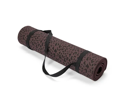 Un tapis de yoga marron à motif léopard noir enroulé, maintenu par une sangle noire.