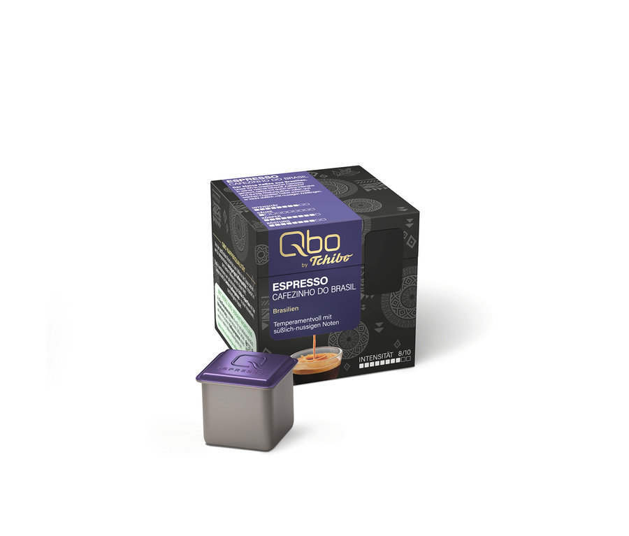 Une capsule de café grise avec un couvercle violet devant une boîte noire à motifs violets, étiquetée « Qbo by Tchibo Espresso Cafezinho do Brasil ».