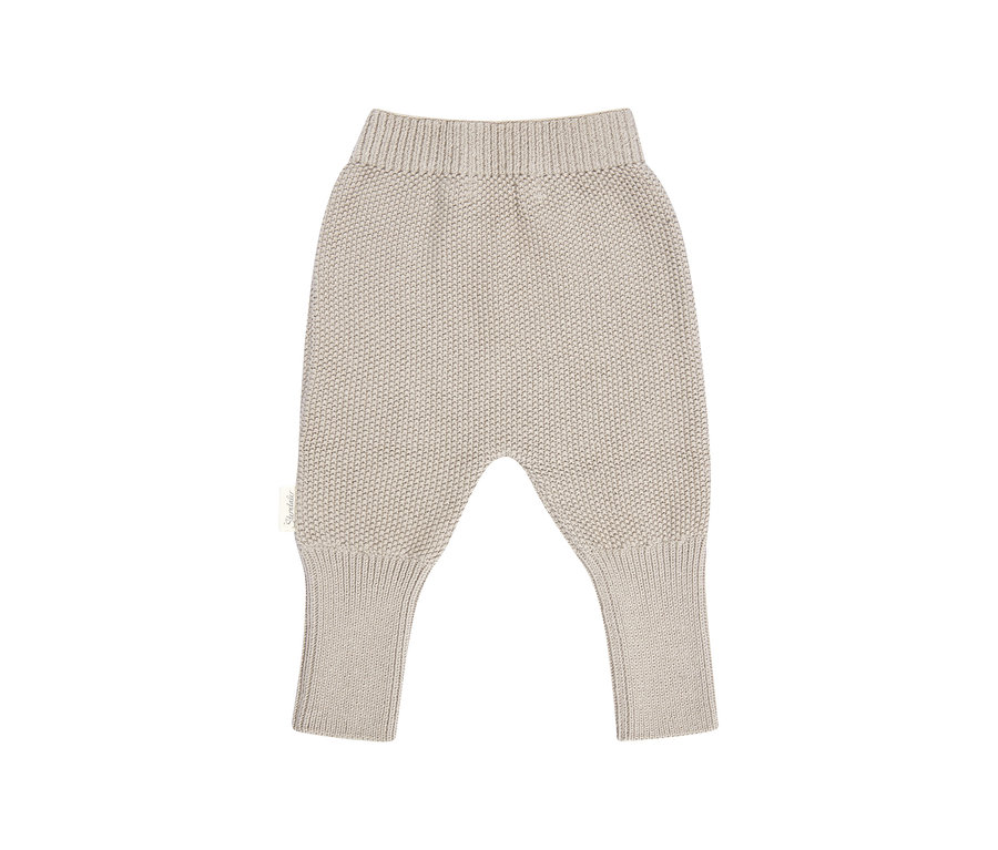 Pantalon bébé en tricot beige clair avec taille et chevilles côtelées, coupe sarouel.