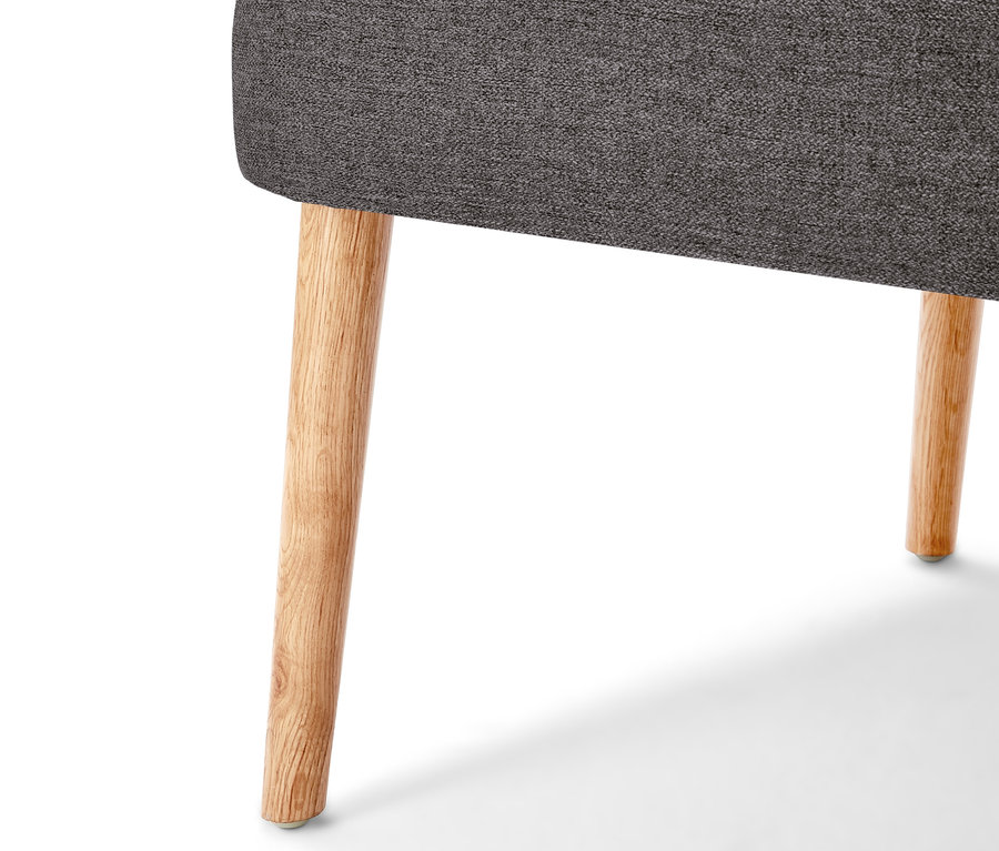 Détail d'un canapé avec des pieds en bois.
