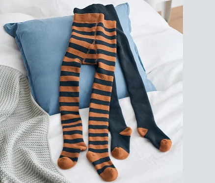 Sur un lit, deux paires de collants thermiques bleus.