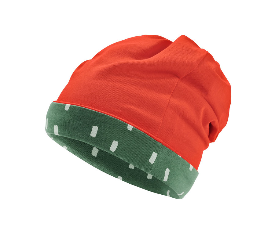 Détail d'un bonnet réversible, orange à l'extérieur et vert avec des points blancs à l'intérieur.