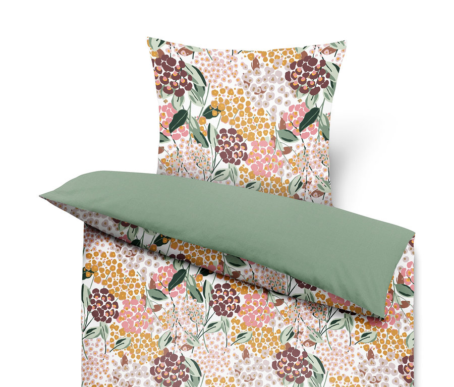 Parure de lit à motif floral avec oreiller vert.