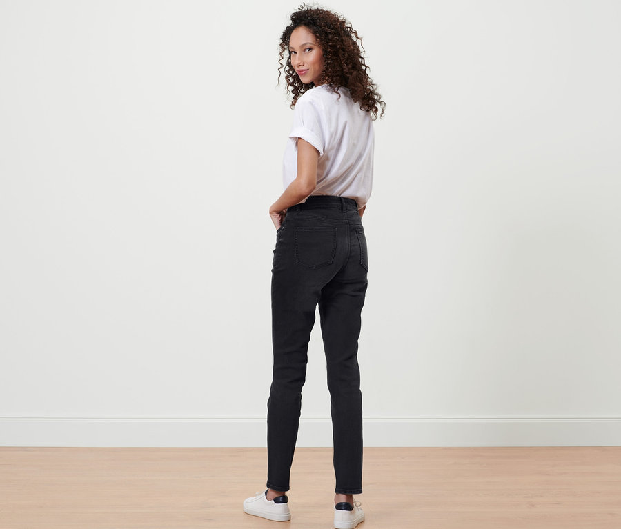 Femme regardant par-dessus son épaule et posant en jean slim en denim « Fit Emma » noir.