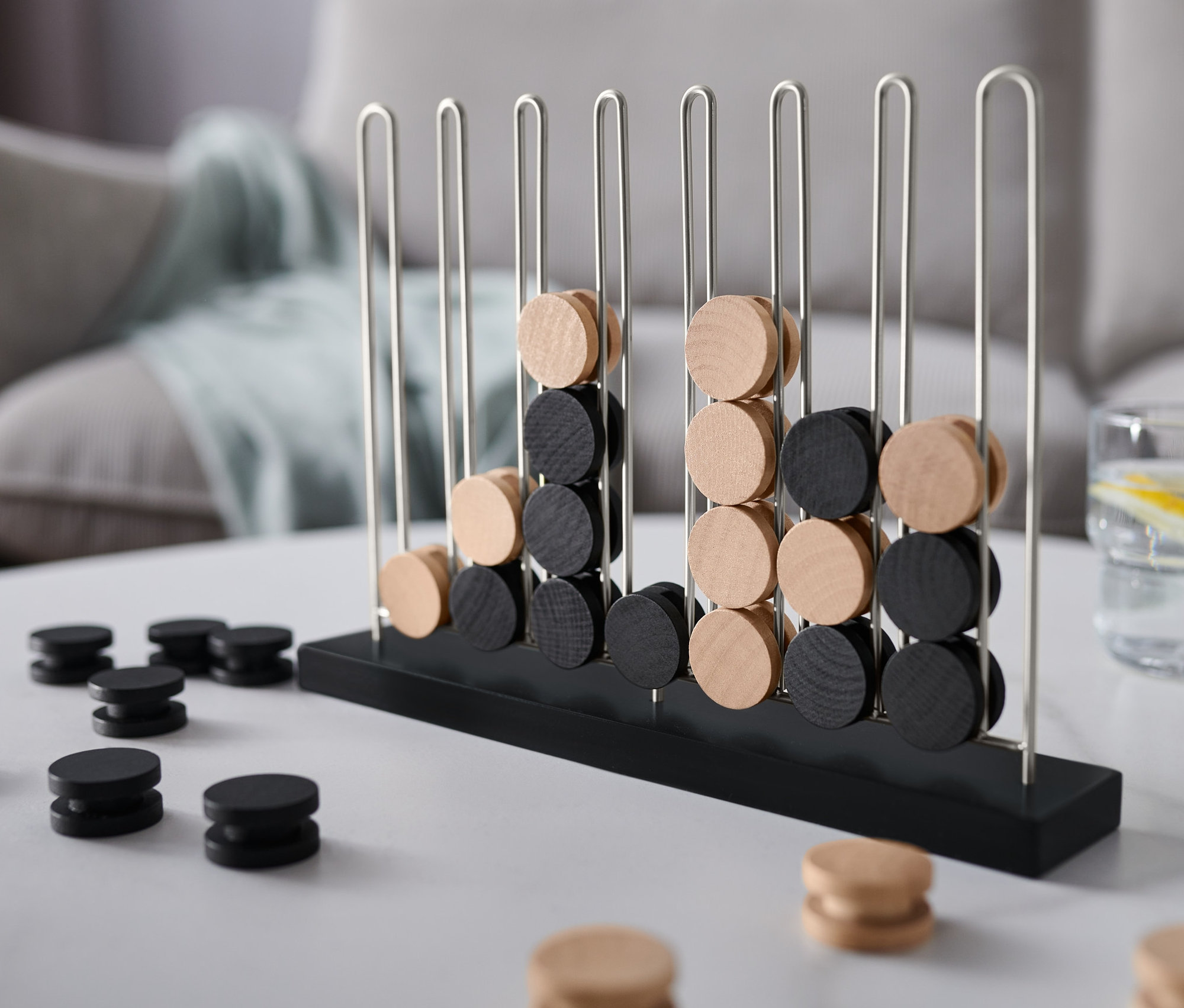 Un jeu noir et beige « 4 en ligne » est posé sur une table.