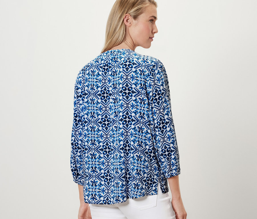 Femme portant un chemisier-tunique imprimé, bleu.