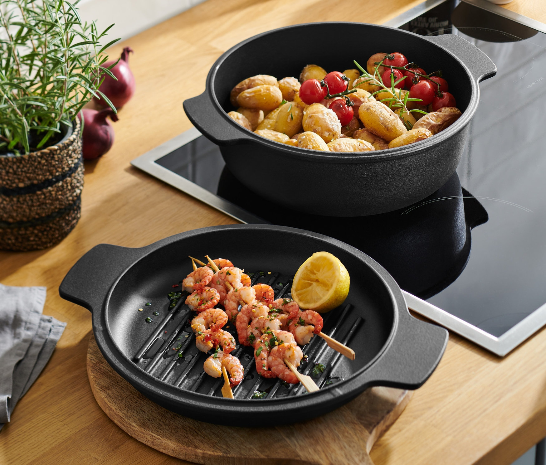Casserole et poêle 2 en 1 en fonte avec brochettes de crevettes et pommes de terre aux tomates cerises.