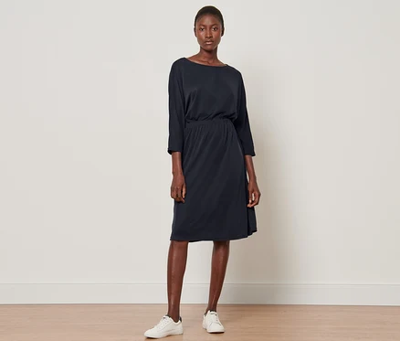 Une femme debout portant une robe en jersey piqué.