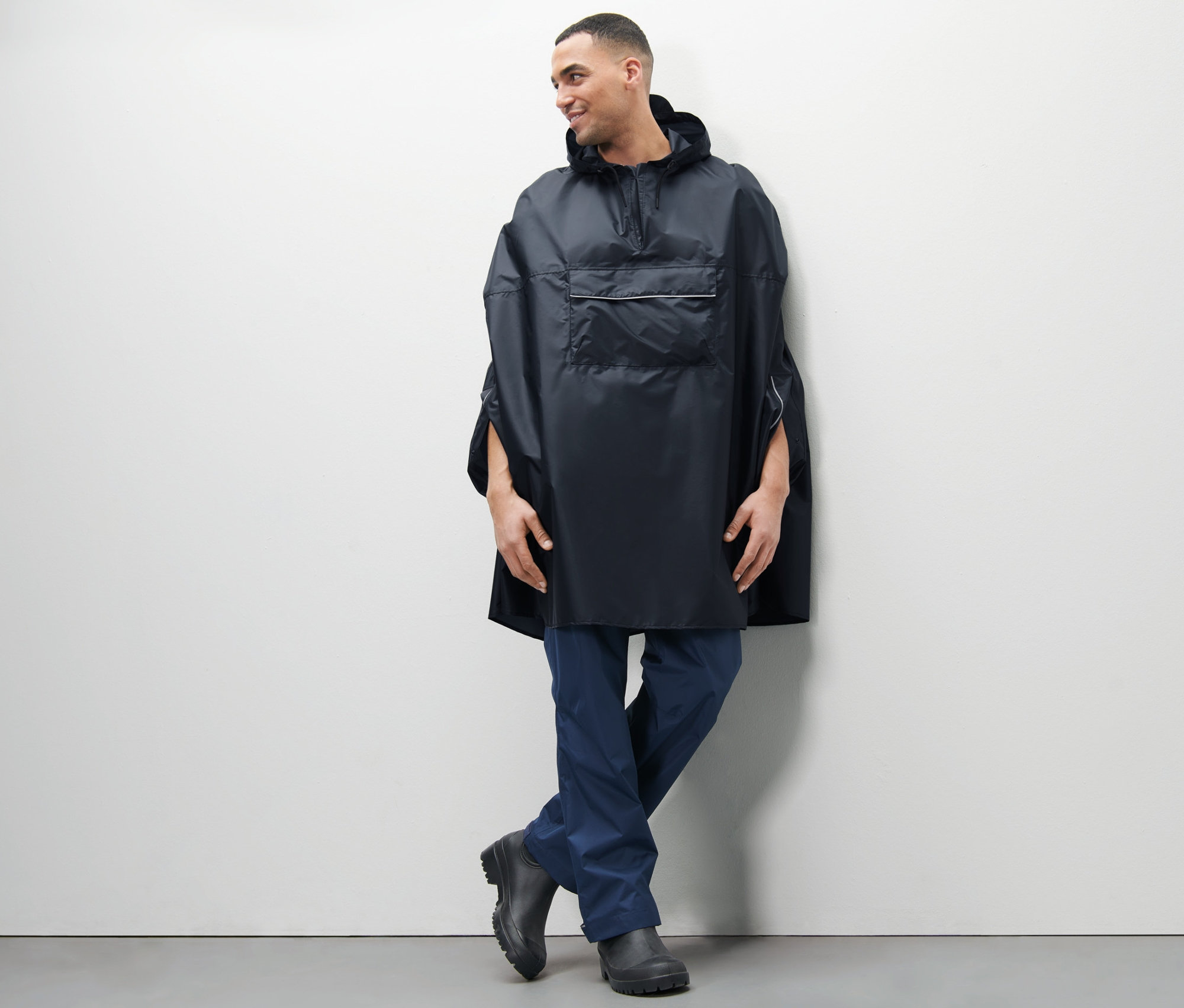 Homme posant en poncho de pluie unisexe bleu.