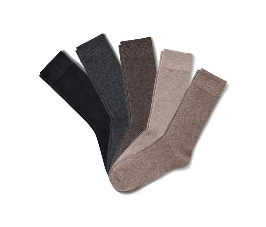 Cinq paires de chaussettes de différentes couleurs sont posées sur un fond blanc.