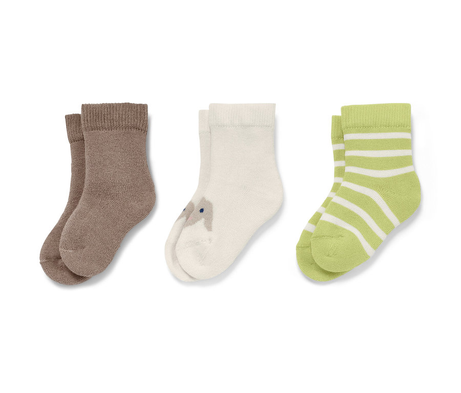 Trois paires de chaussettes pour bébé : marron, crème avec motif lapin et vert rayé blanc.