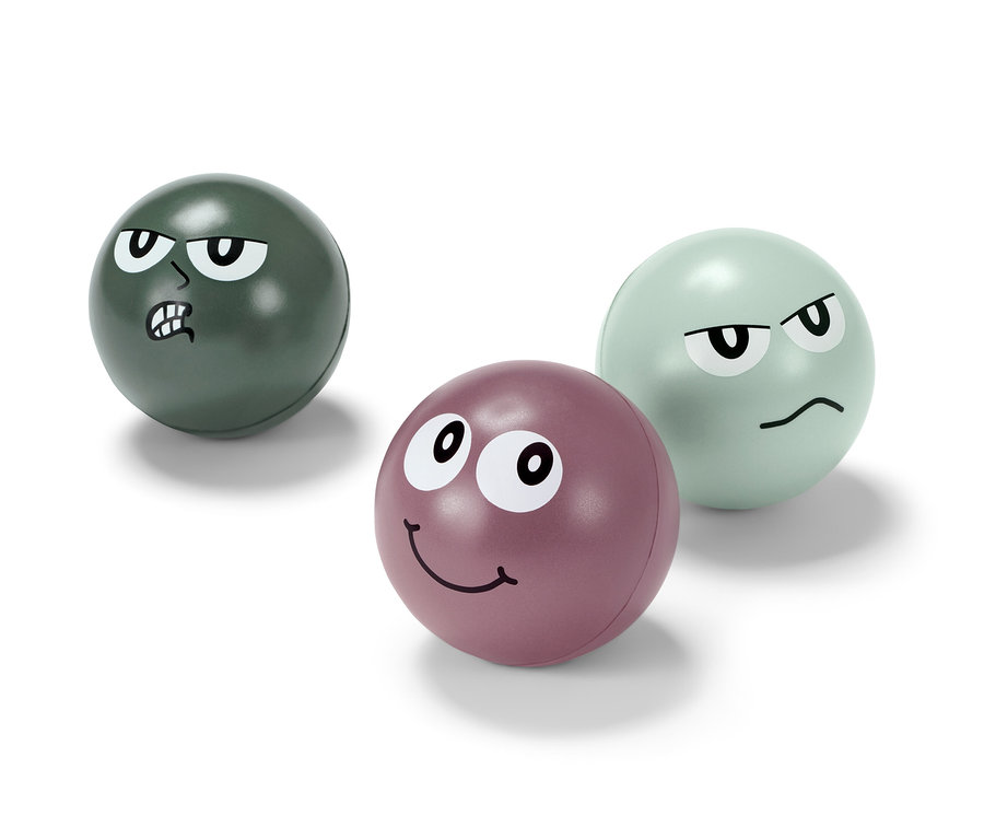 Trois balles antistress avec des visages. L'une est verte avec une expression fâchée, l'autre est violette avec une expression souriante et la troisième est vert clair avec une expression contrariée.