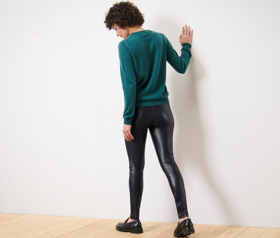 Une femme dos à la caméra porte un legging aspect cuir.