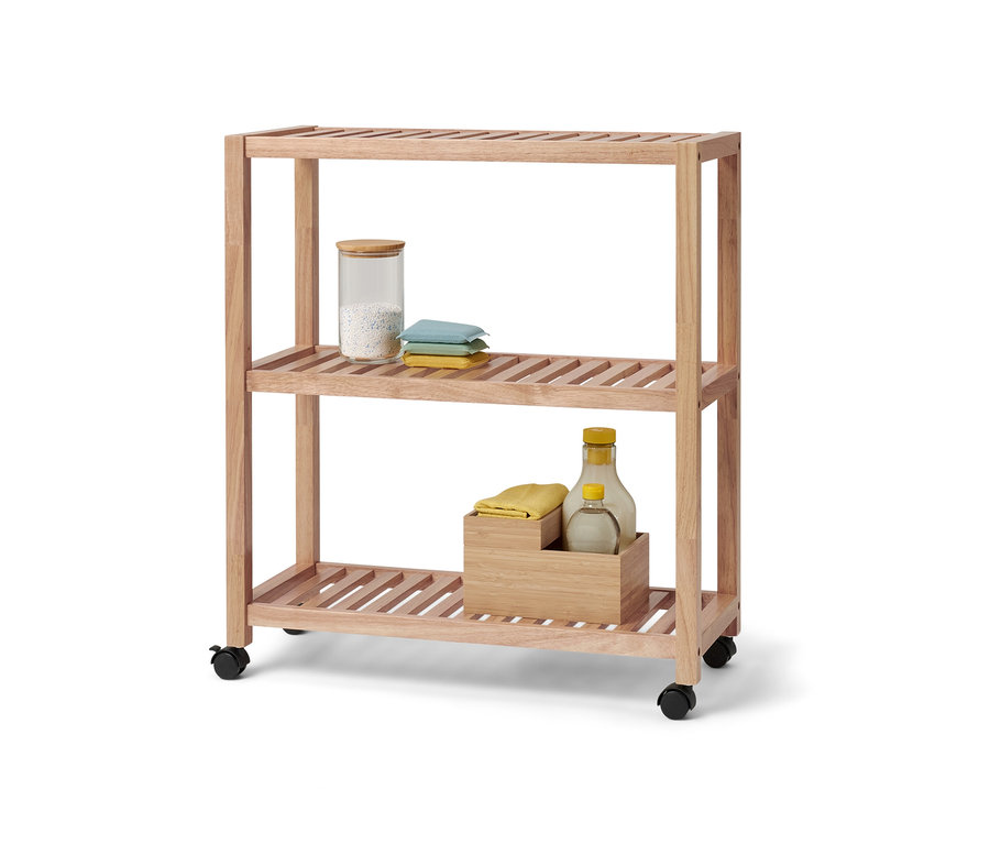 Étagère à trois niveaux en bois massif avec roulettes. Un récipient en verre et des textiles sont placés sur l'étagère supérieure.