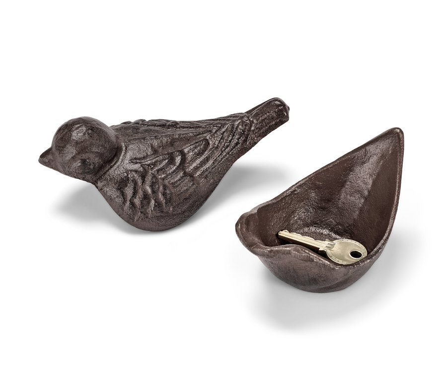 Une cachette pour clés marron en forme d'oiseau et de bol, avec une clé dans le bol.