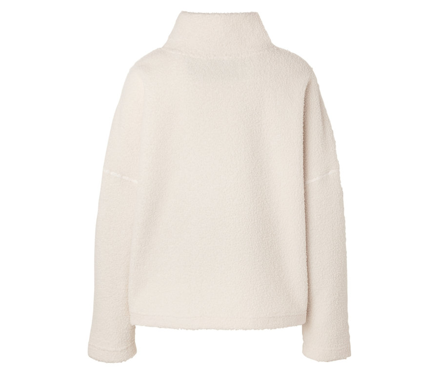Gros plan d'un pull en polaire crème à col montant.