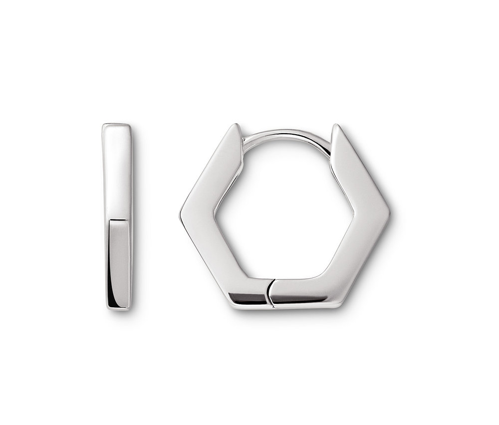 Deux boucles d'oreilles argentées hexagonales reposent sur un fond blanc.
