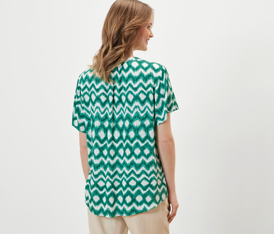 Femme portant un chemisier-tunique imprimé.