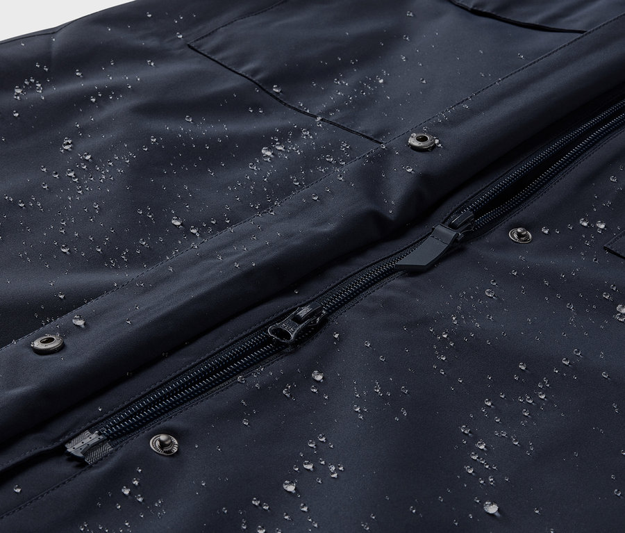 Gros plan sur un trench-coat de pluie avec des gouttes d'eau.