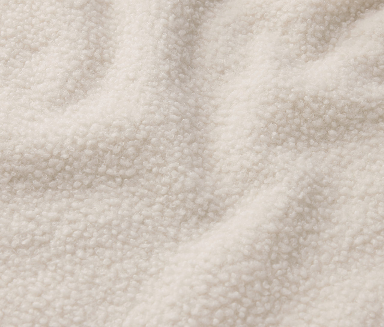 Gros plan sur un tissu en peau lainée crème.